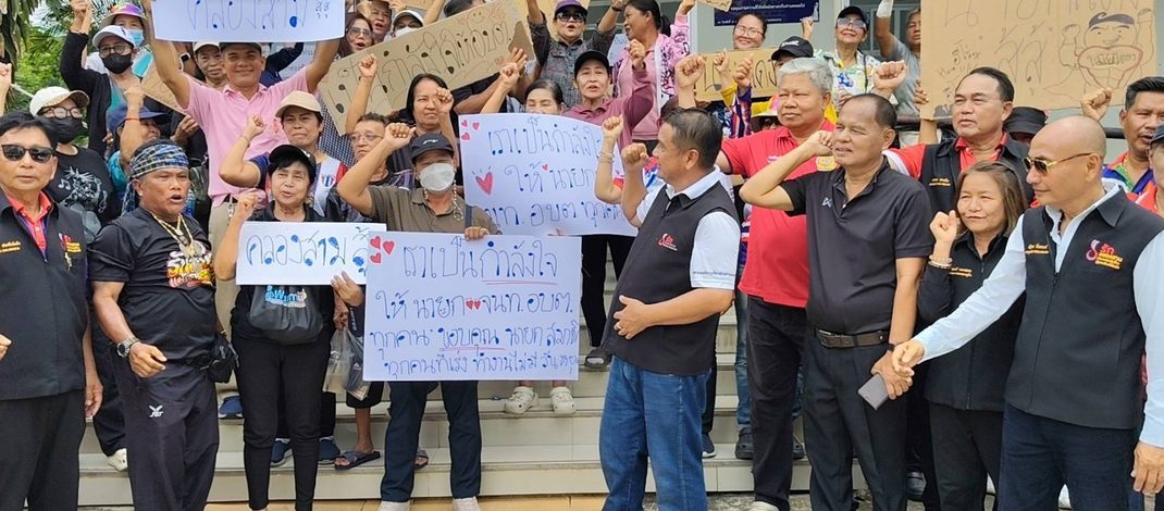 ปทุมธานี ชาวบ้านกว่า 30 รายถือป้ายให้กำลังใจนายก อบต. และเจ้าหน้าที่อบต. หลังเกิดดราม่าพรรคดังเตรียมยกขบวนจี้เรื่องเงินเยียวยาน้ำท่วม