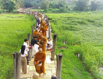 วัดภูสมะณาราม ตักบาตรเทโวโรหณะในเทศกาลออกพรรษา บนสะพานซูตองเป้ แหล่งท่องเที่ยวชื่อดังของแม่ฮ่องสอน แม้คนมาทำบุญน้อยจากสภาวะเศรษฐกิจซบเซา